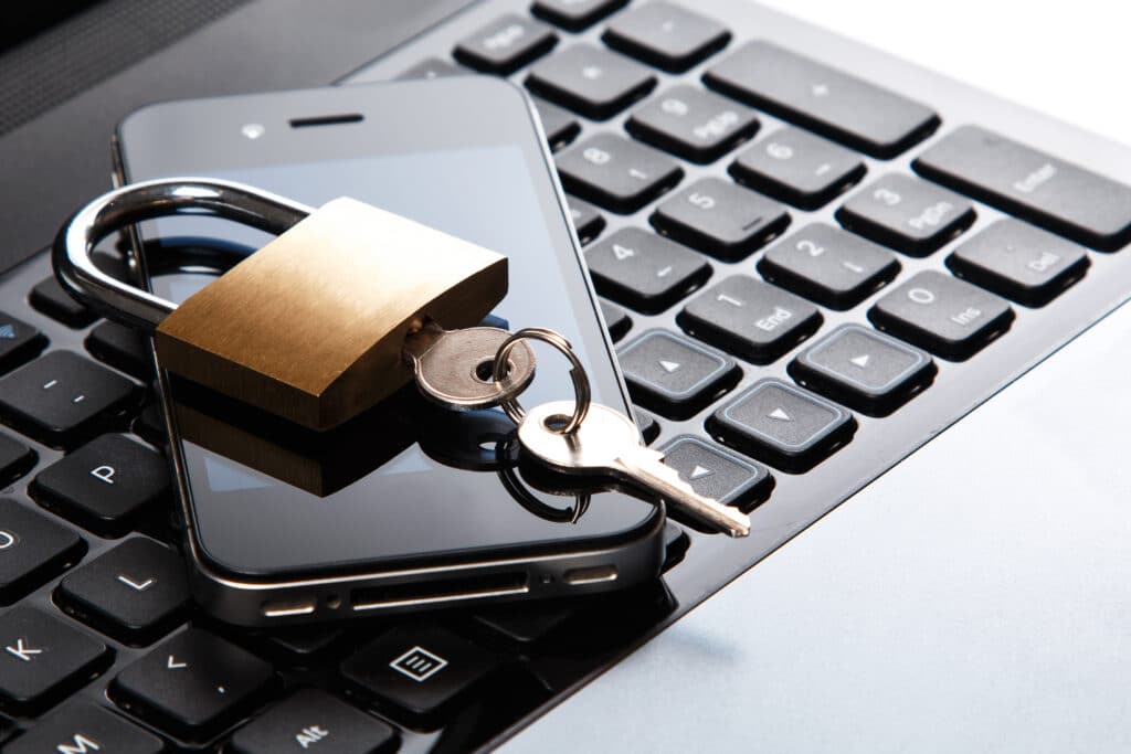 lock with key on top of phone and laptop - 4 Benefits of Cloud Migration For Your Business