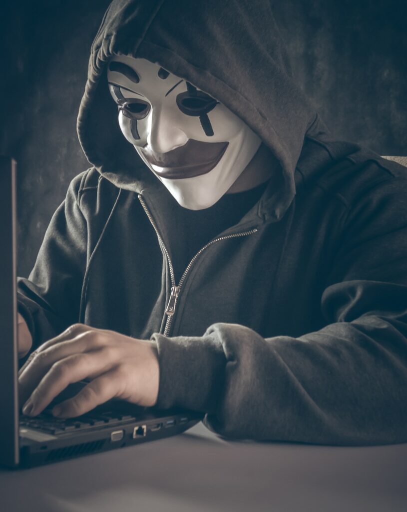 hacker in mask at laptop - Our Top 5 Data Loss Prevention Strategies