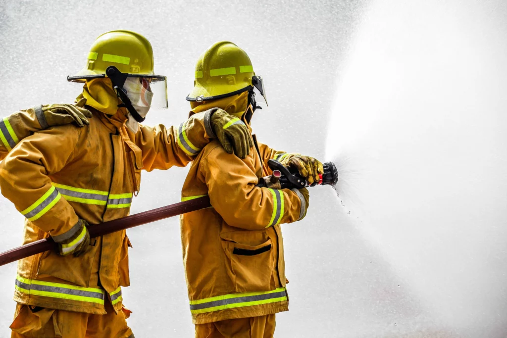 two firemen holding hose