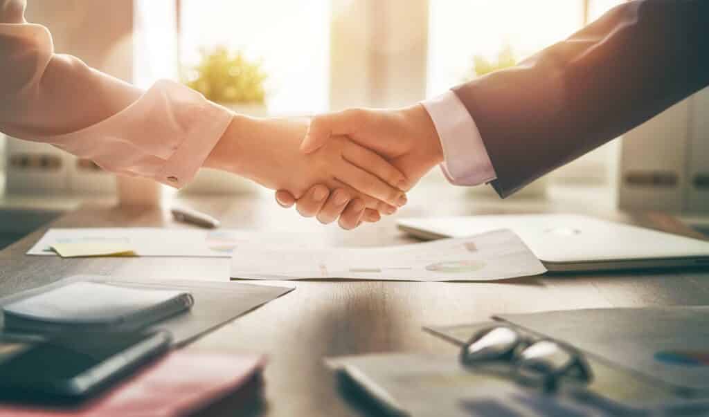 Man and woman are shaking hands in office