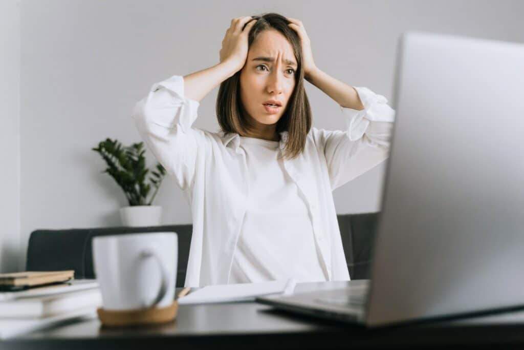 what to do if personal data is compromised - cybersecurity - woman with hands on head looking shocked at laptop