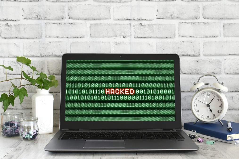 ransomware and malware - computer screen showing coding and the word Hacked