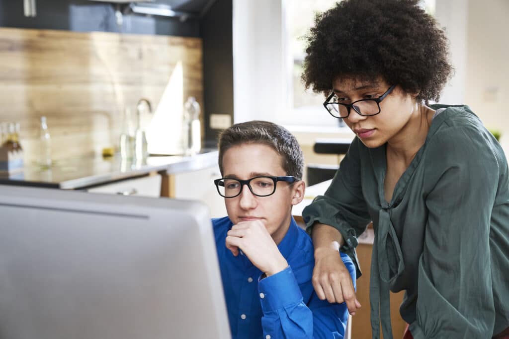 coworkers looking at computer online scame